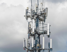 Telecom tower with clouds behind it